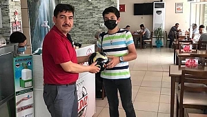 Muhtar Suat Gölcük mahallesindeki çalışkan öğrencilerin karnesini getirmesi sonucu futbol topu hediye etti